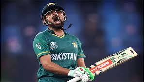Babar Azam in Pakistan cricket jersey celebrating a century, showing his iconic batting stance with the crowd cheering in the background.