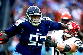 Jermaine Johnson and T’Vondre Sweat posing together on the football field in team uniforms